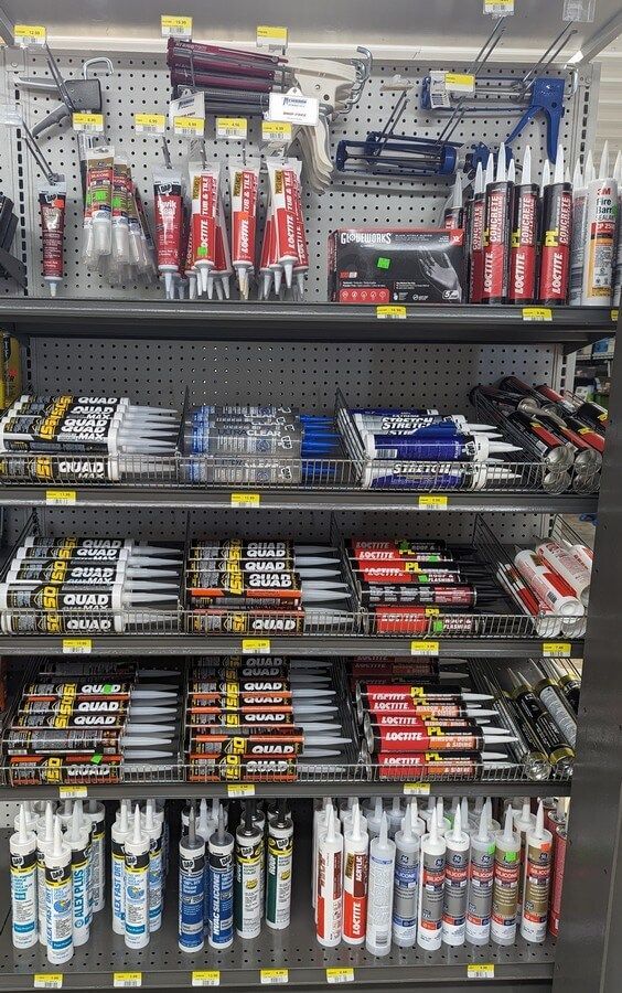 A store shelf filled with lots of different types of adhesives.