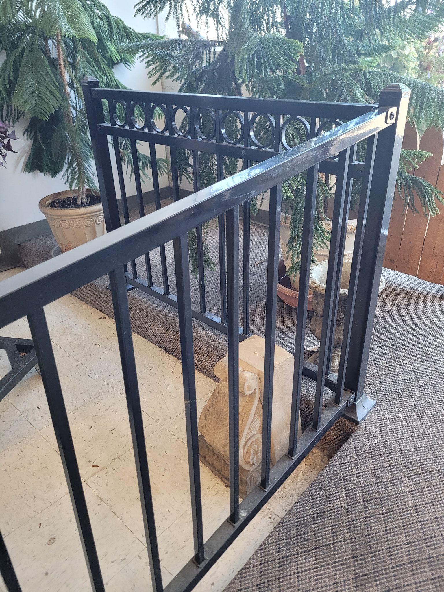Chain-link fence topped with razor wire against a blue sky with clouds.