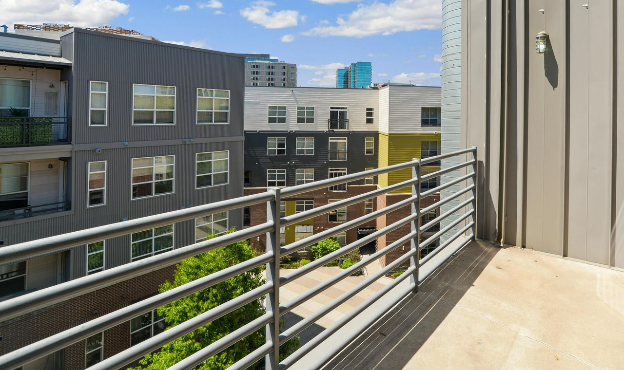 Barbed wire fence against a cloudy blue sky.