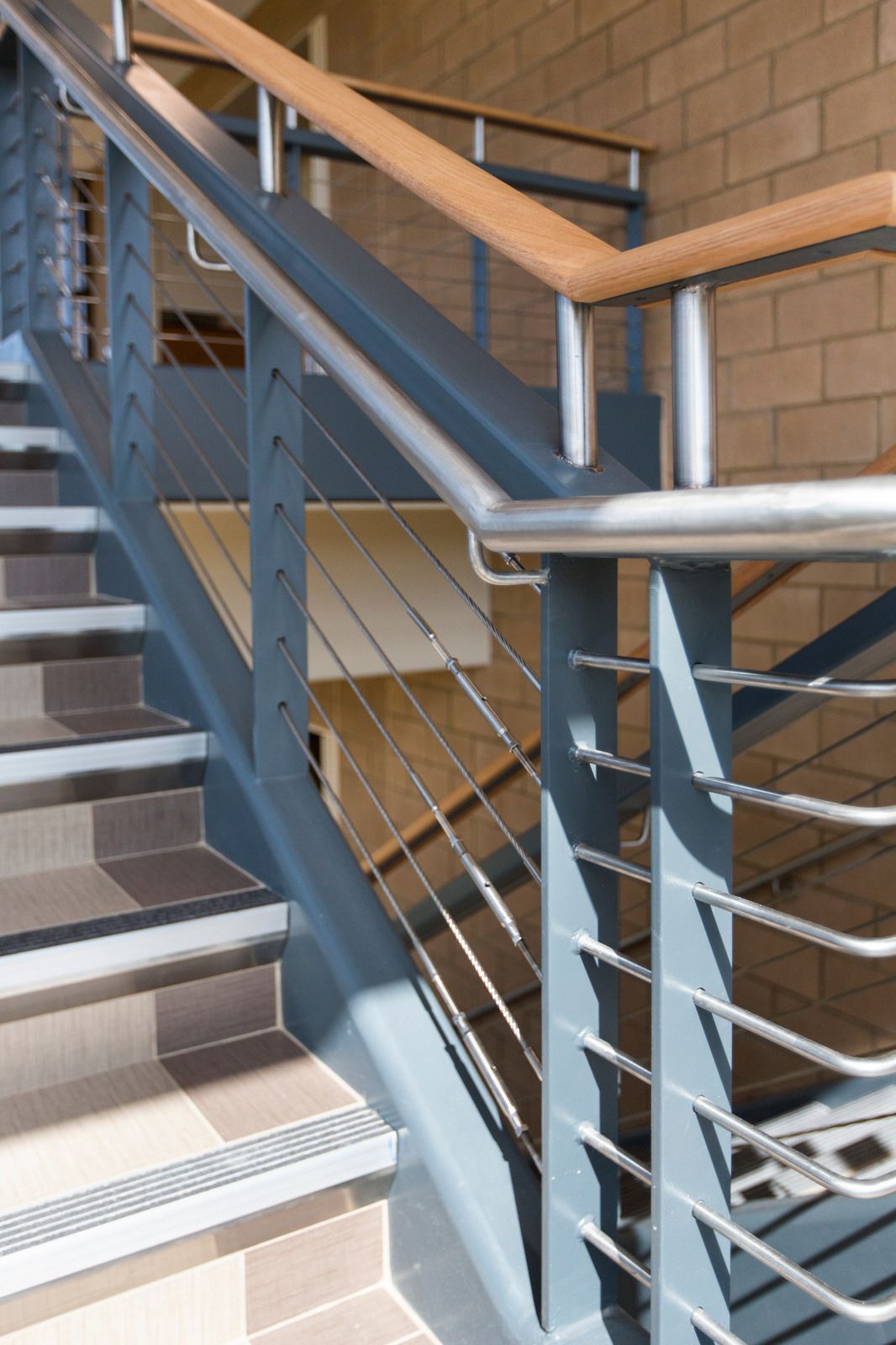 Chain-link fence topped with razor wire against a blue sky with clouds.