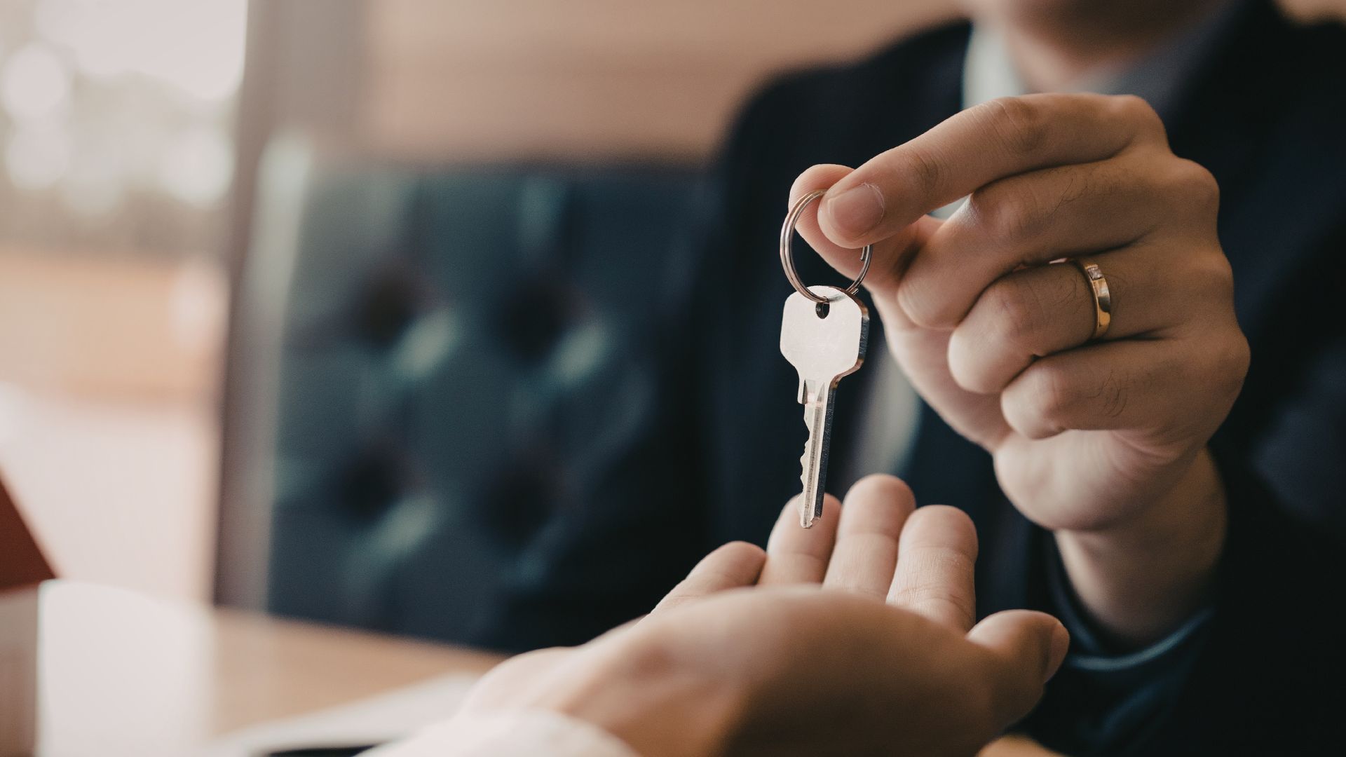 A close-up of someone handing a key to another person 