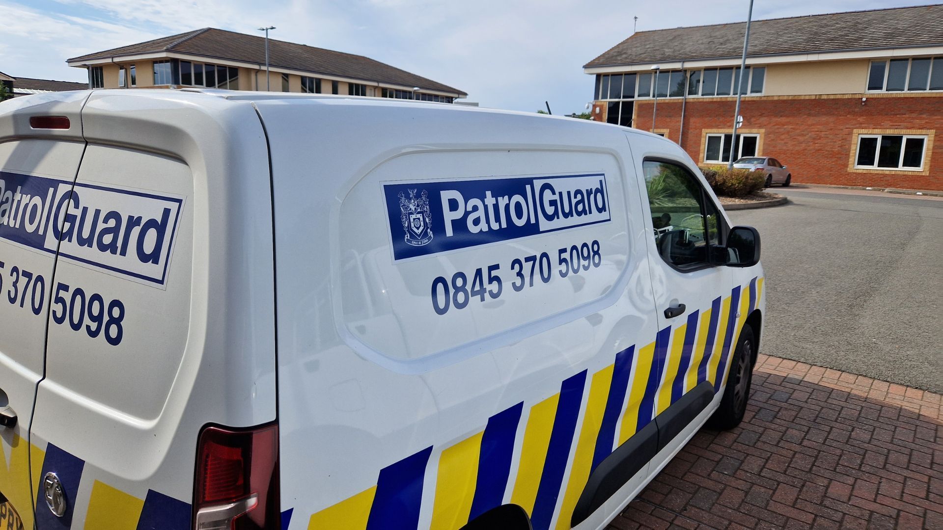 A PatrolGuard van parked outside commercial buildings.