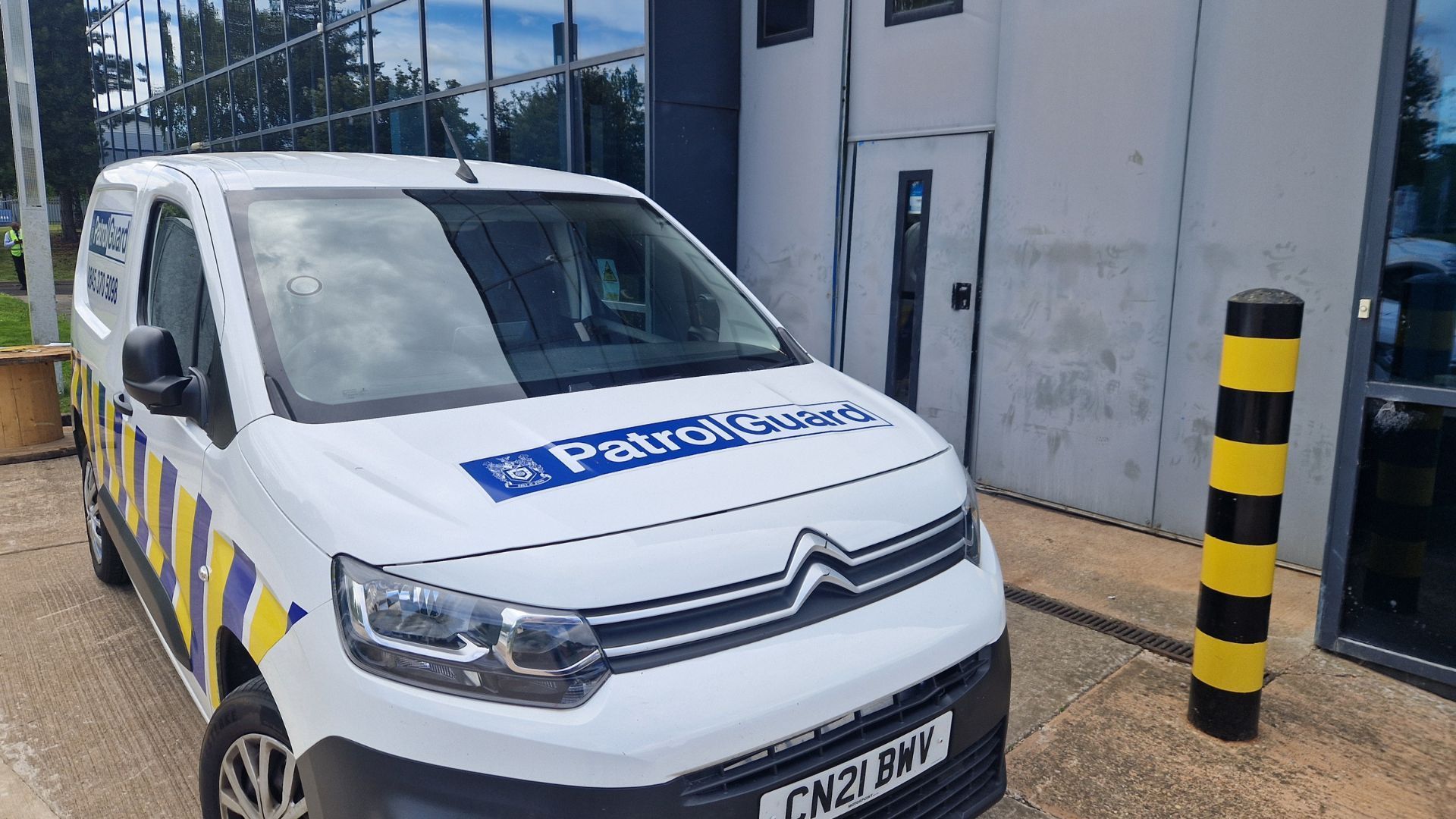 A PatrolGuard van parked outside a building next to a bollard.
