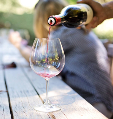 A bottle of wine is being poured into a wine glass