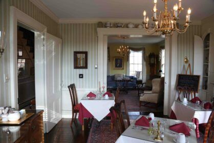 A dining room with tables and chairs and a chandelier.