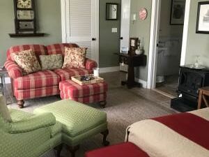 A living room with a couch , chair , ottoman , and fireplace.