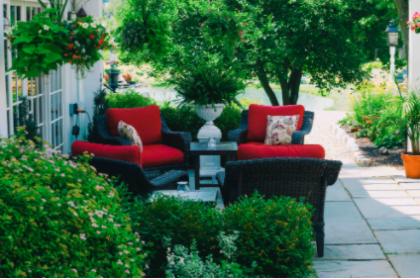 A patio with red chairs and a table