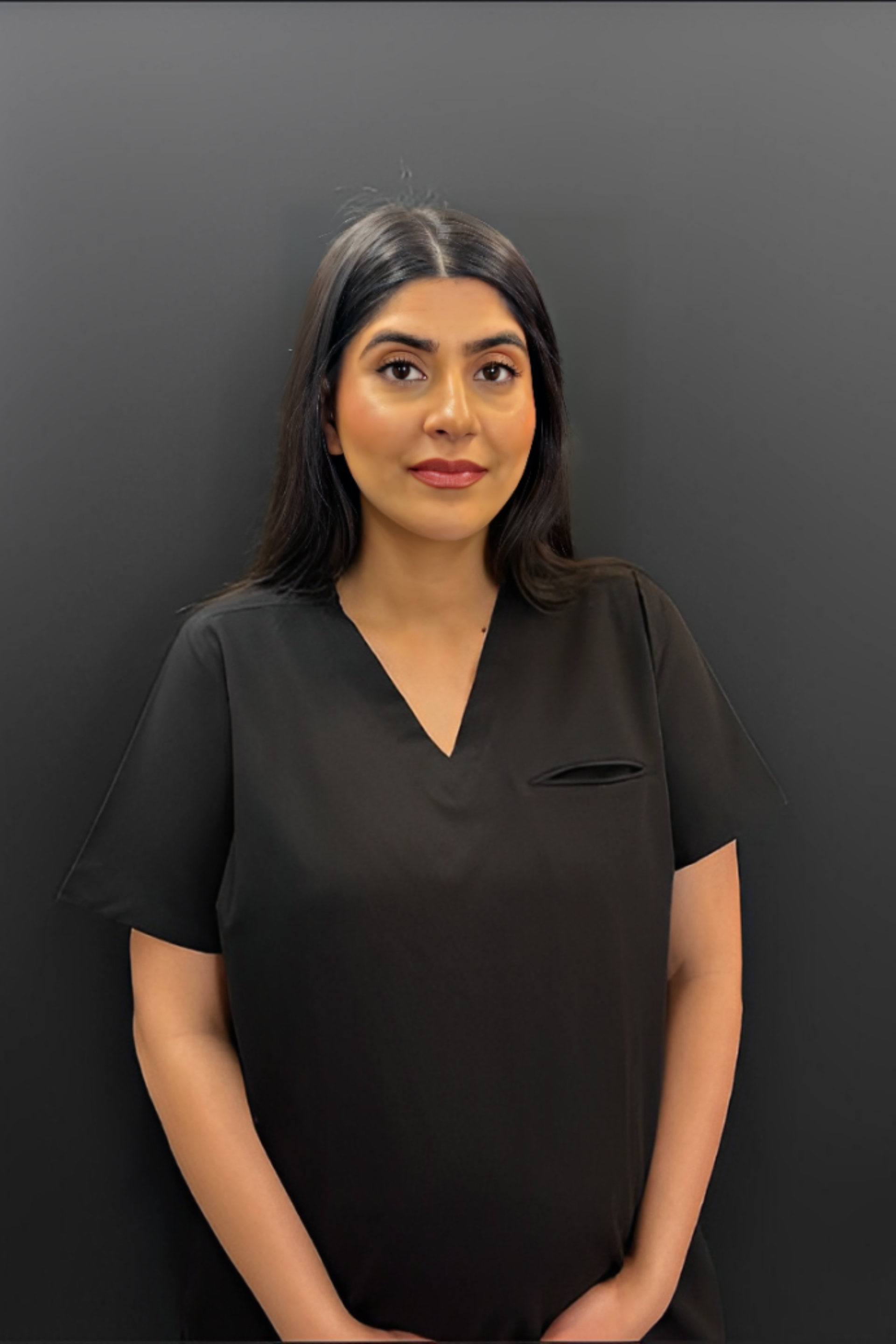 A woman with curly hair is wearing a white lab coat and a black shirt.