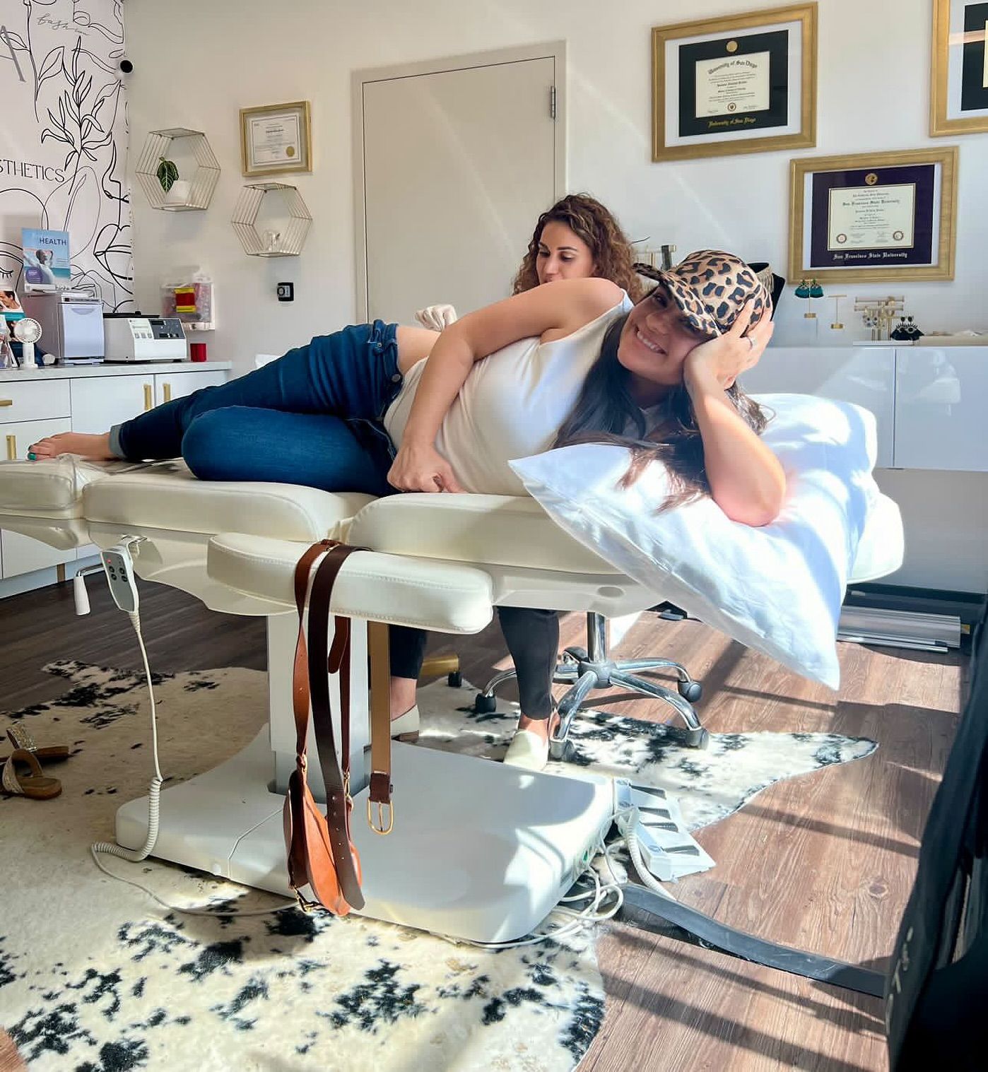 A woman in a leopard print hat is laying on a massage table.