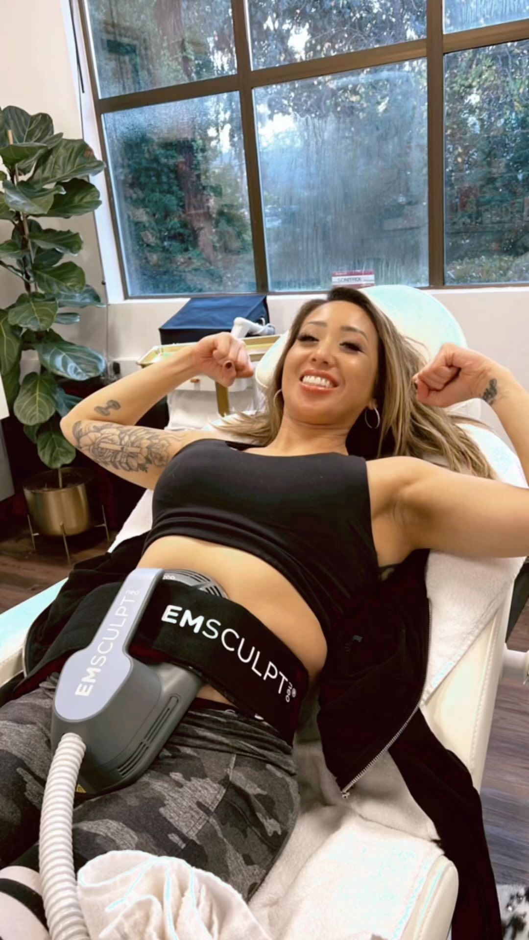 A woman is sitting in a chair with a machine on her stomach.