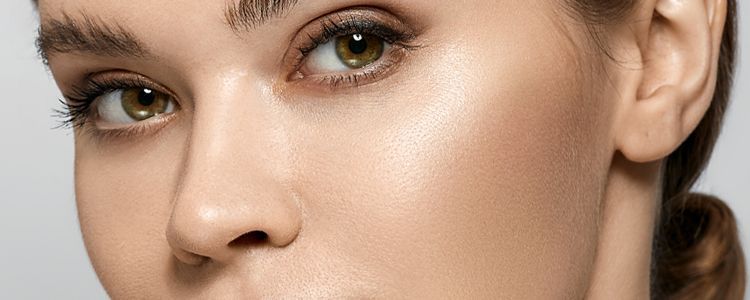 A close up of a woman 's face with a ponytail.