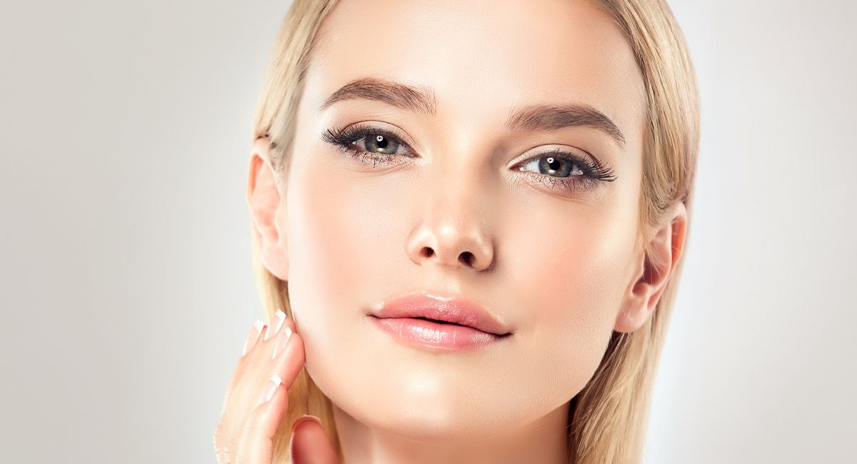 A close up of a woman 's face with a hand on it.