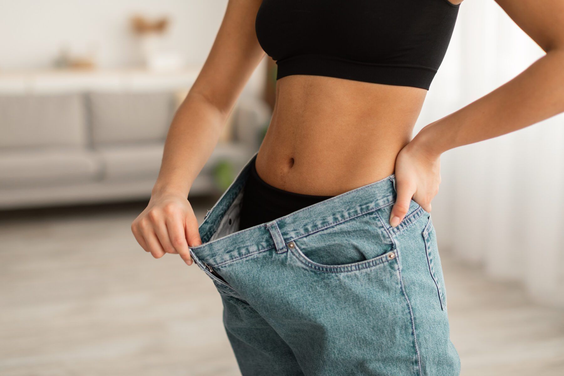 A woman is wearing a pair of very large jeans.