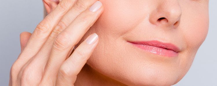 A close up of a woman 's face with her hand on it.
