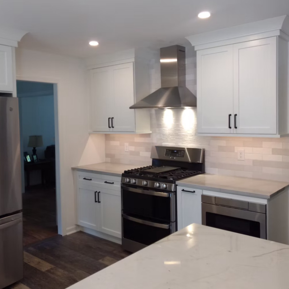 A kitchen with white cabinets and stainless steel appliances