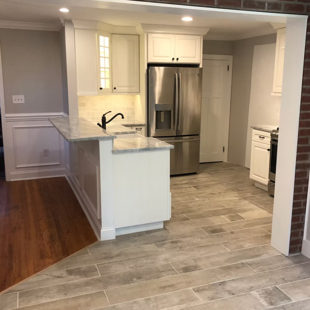 A kitchen with a stainless steel refrigerator and a sink.