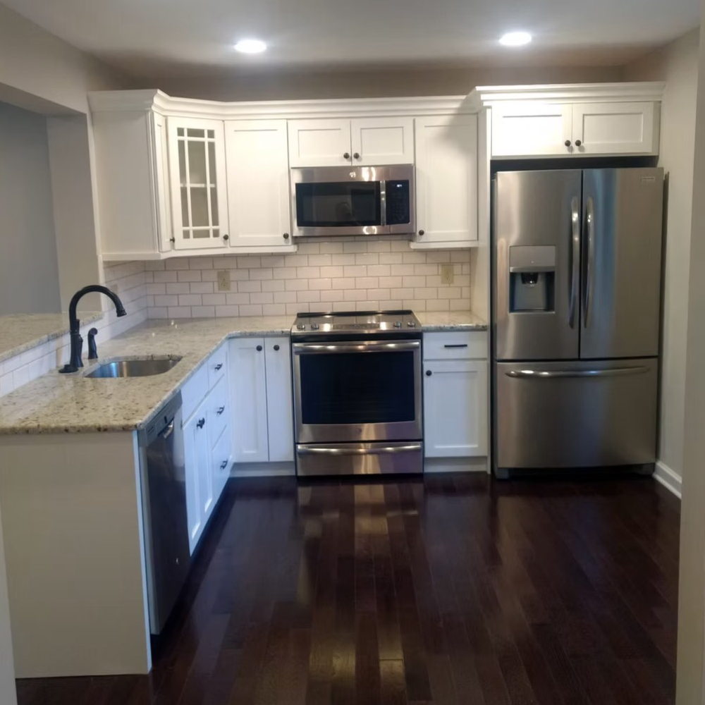 A kitchen with stainless steel appliances and white cabinets