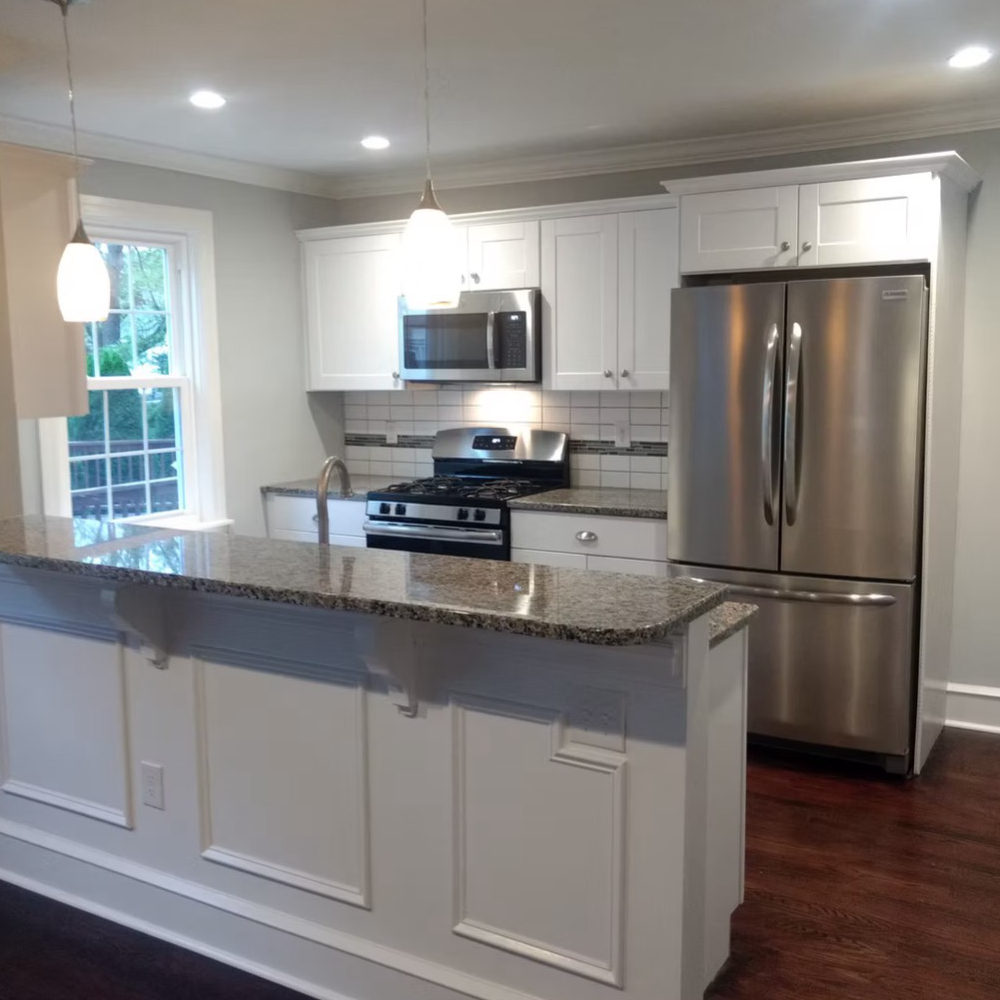 White kitchen with granite countertop island and stainless steel appliances.