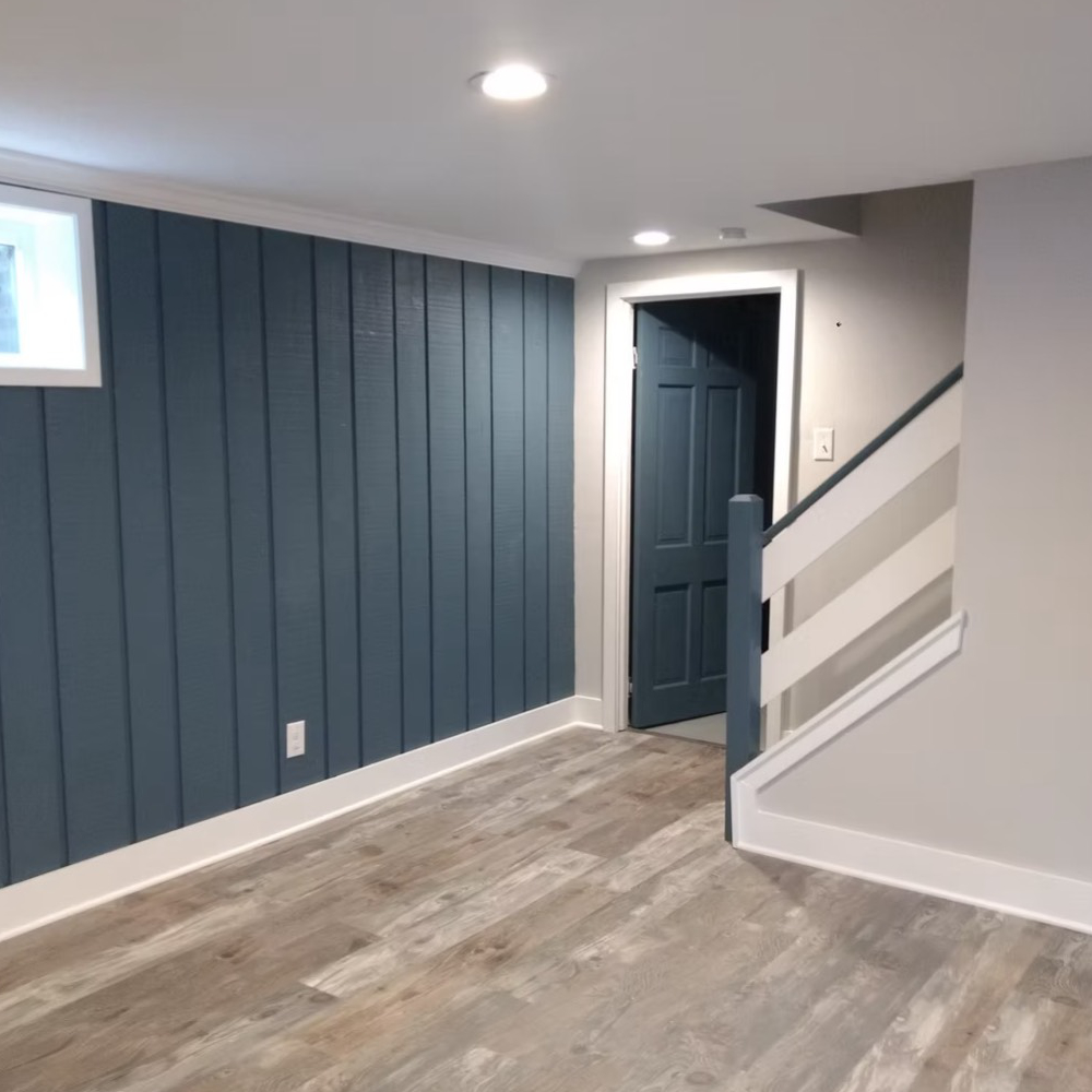 An empty room with a staircase and a door