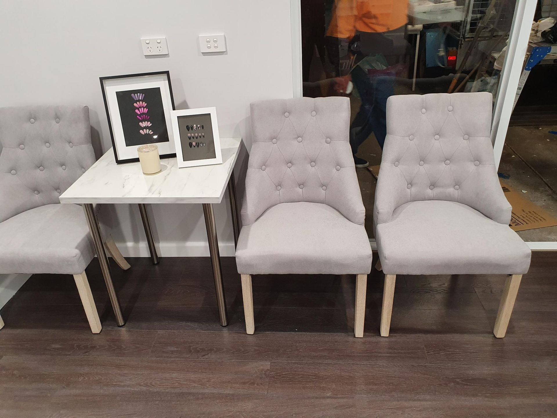 Three Gray Tufted Chairs Near a Small Table with Framed Art — Mezcon Group in Heidelberg, VIC