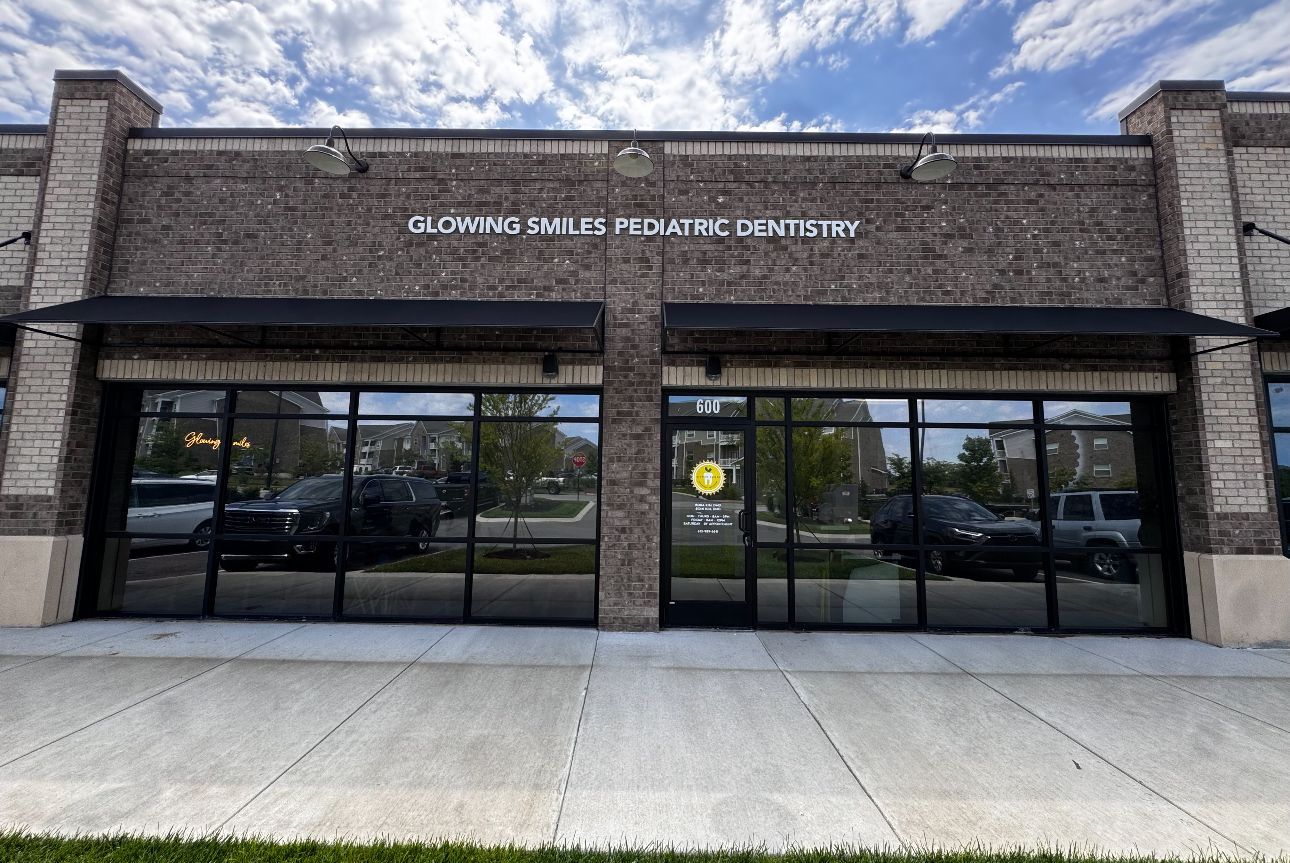 Two people buffing a car's chrome trim with electric polishers.