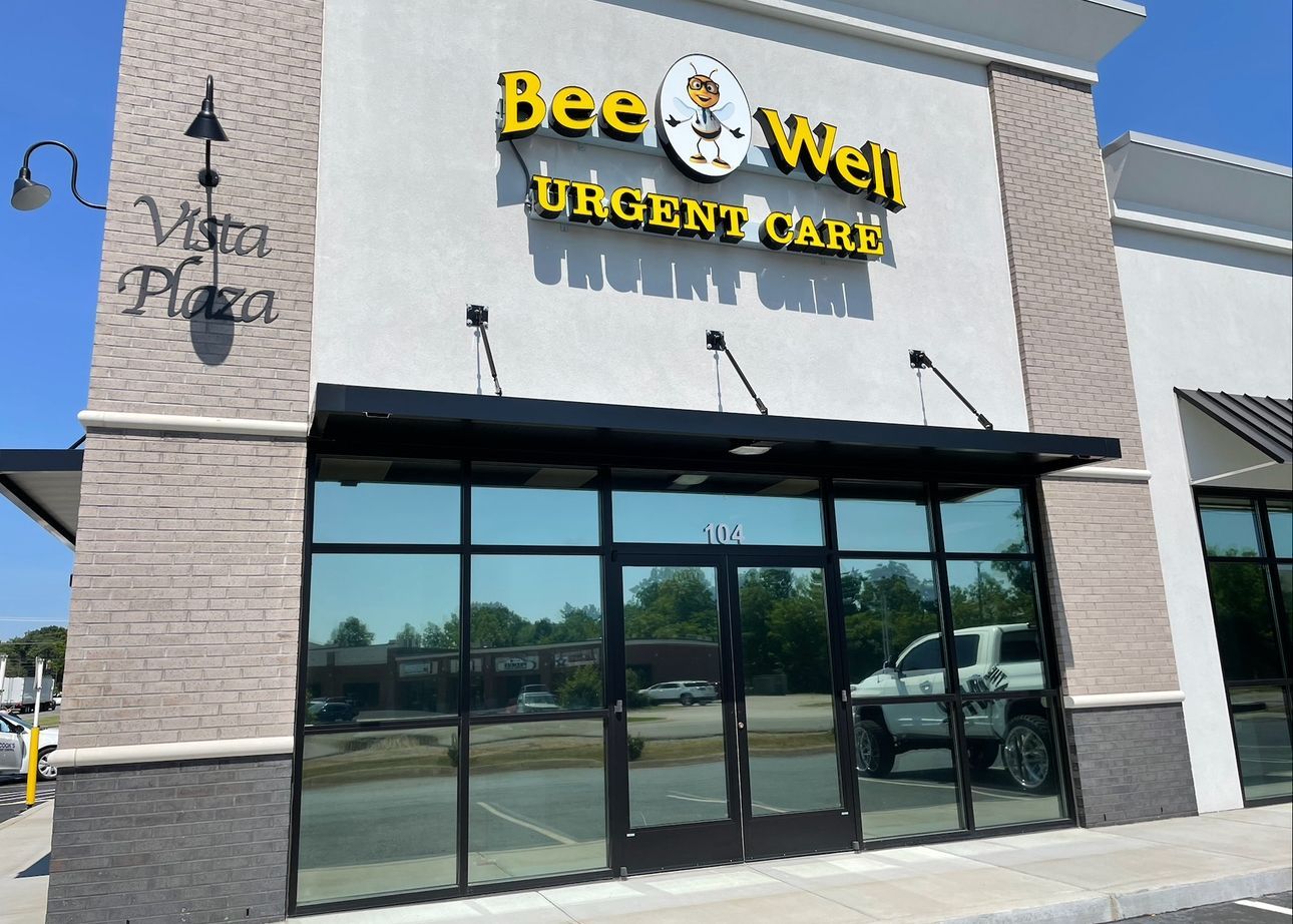 Two people buffing a car's chrome trim with electric polishers.
