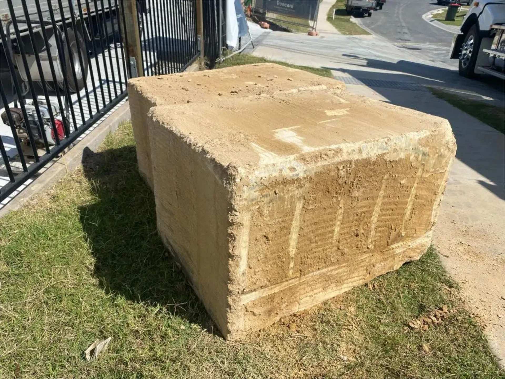 A large sandstone block is sitting on top of a lush green lawn.