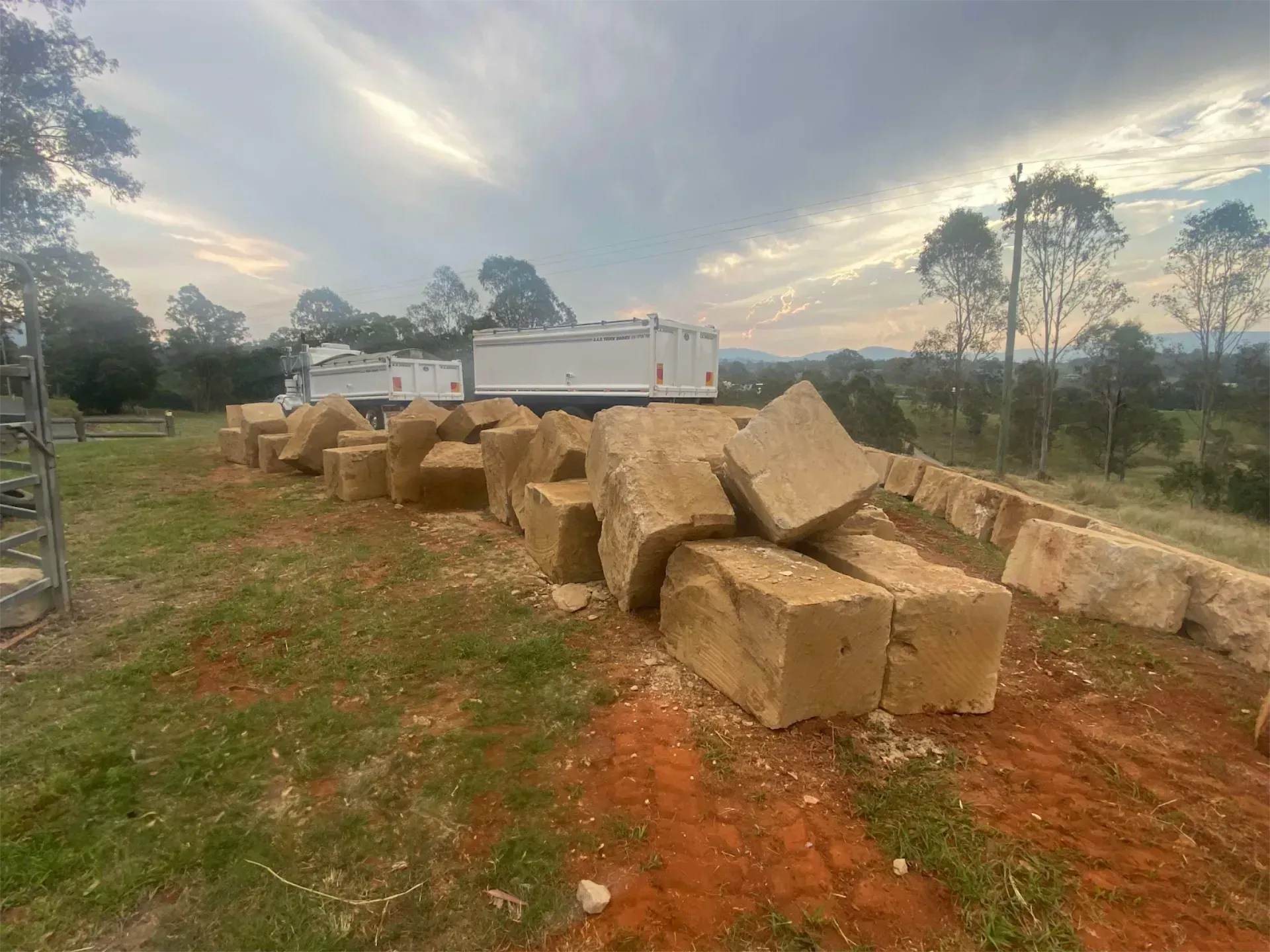 A bunch of sandstone bricks are sitting on top of each other in a field.