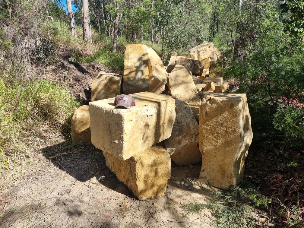 A pile of sandstone rocks sitting on top of each other in the middle of a forest.