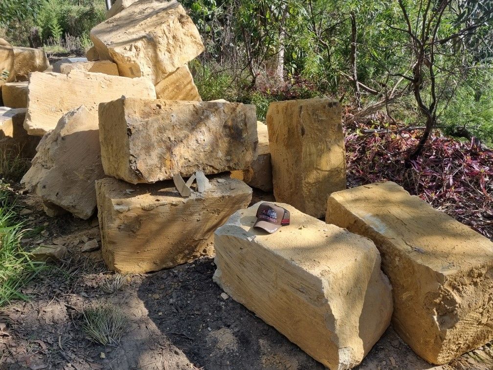 A pile of sandstone rocks sitting on top of each other on the ground.