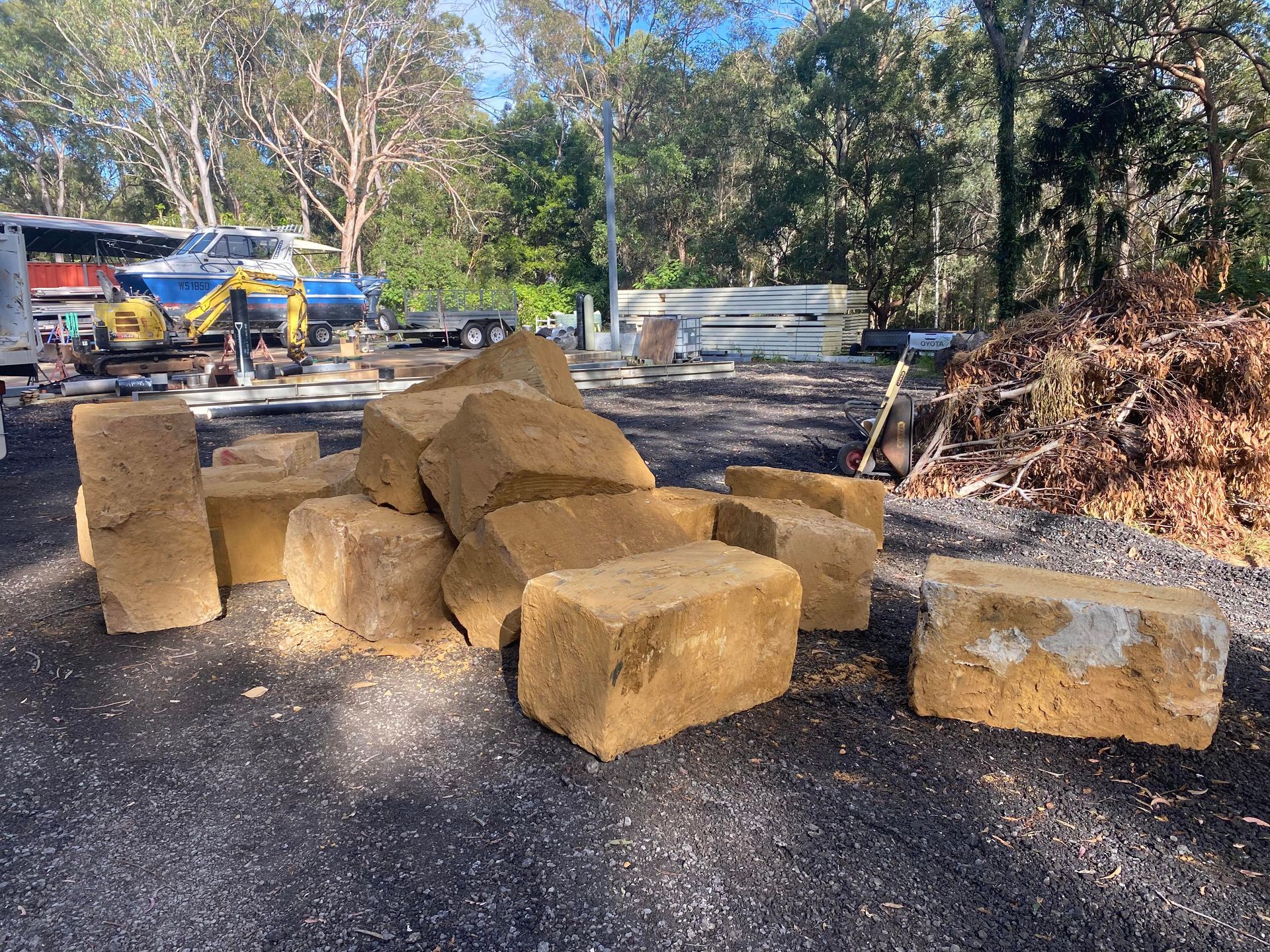 A pile of sandstone bricks is sitting on the ground in a parking lot.