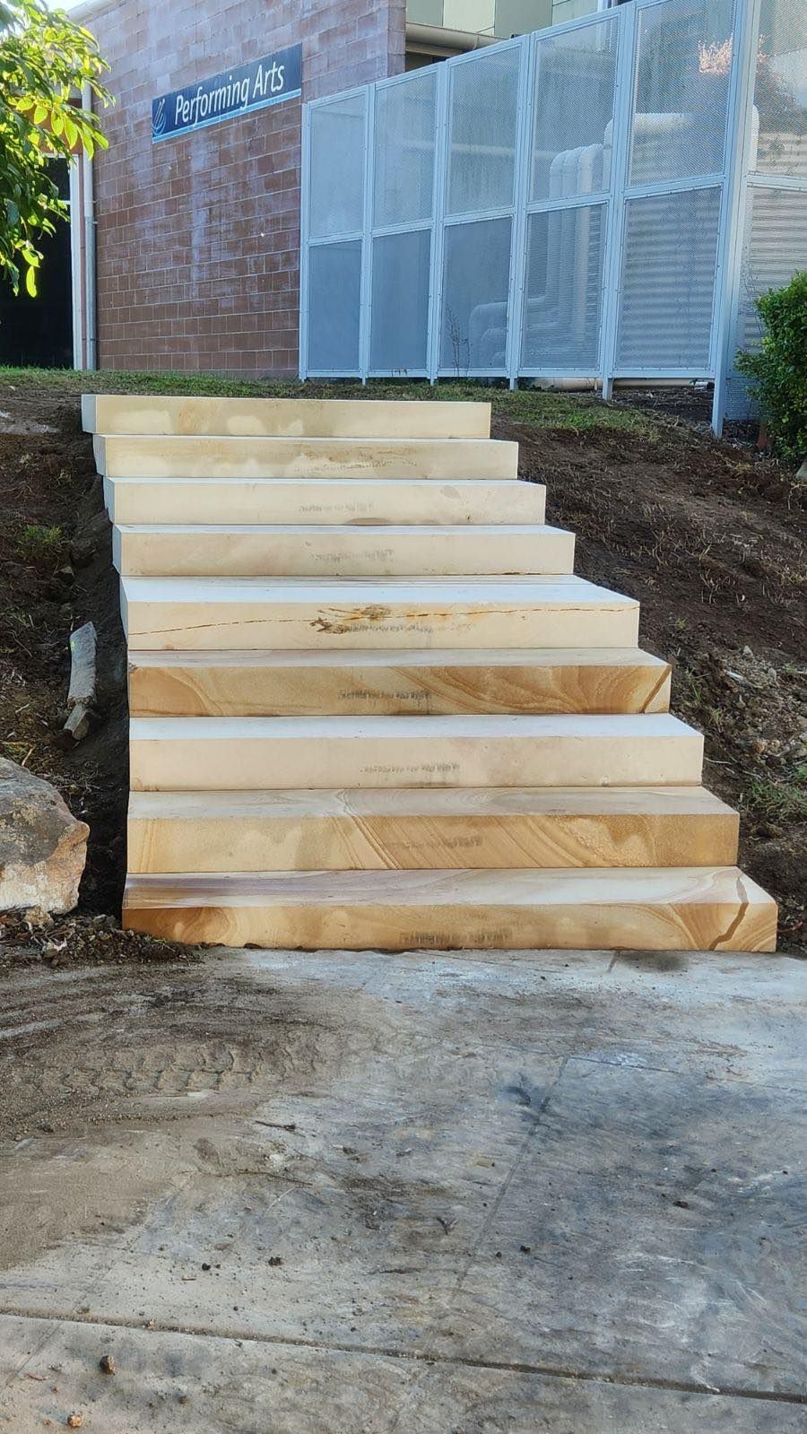 A set of sandstone stairs leading up to a building.