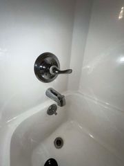 A white bathtub with a chrome faucet in a bathroom.