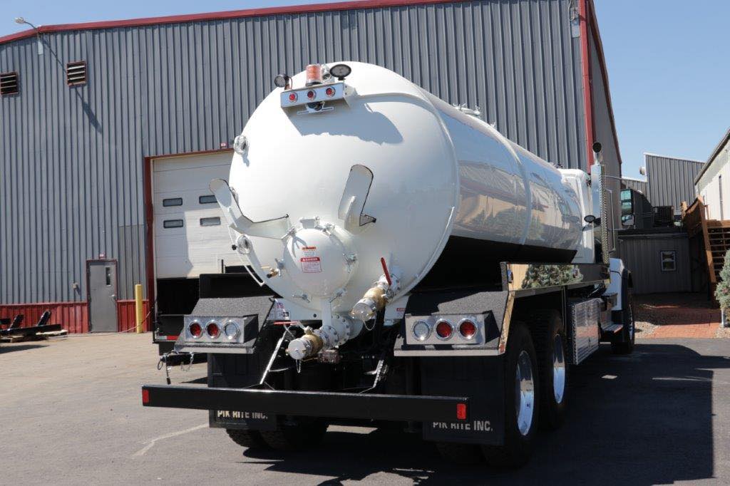 A large white truck is parked in front of a building