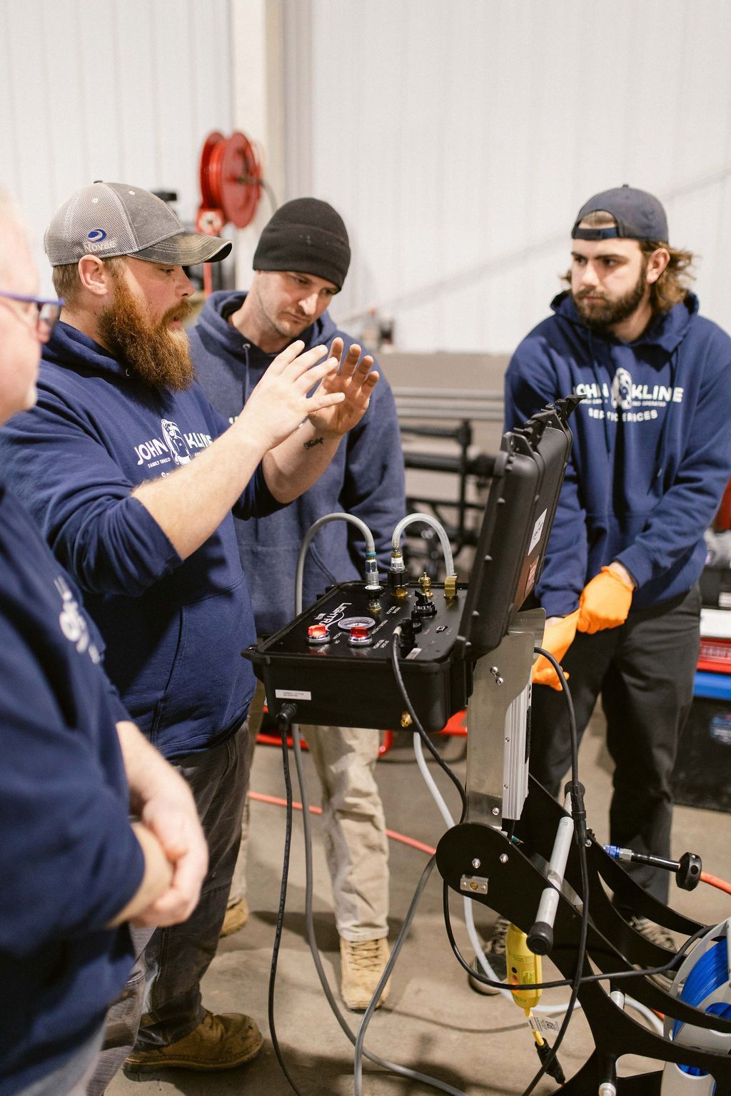 A group of men are standing around a machine in a warehouse.