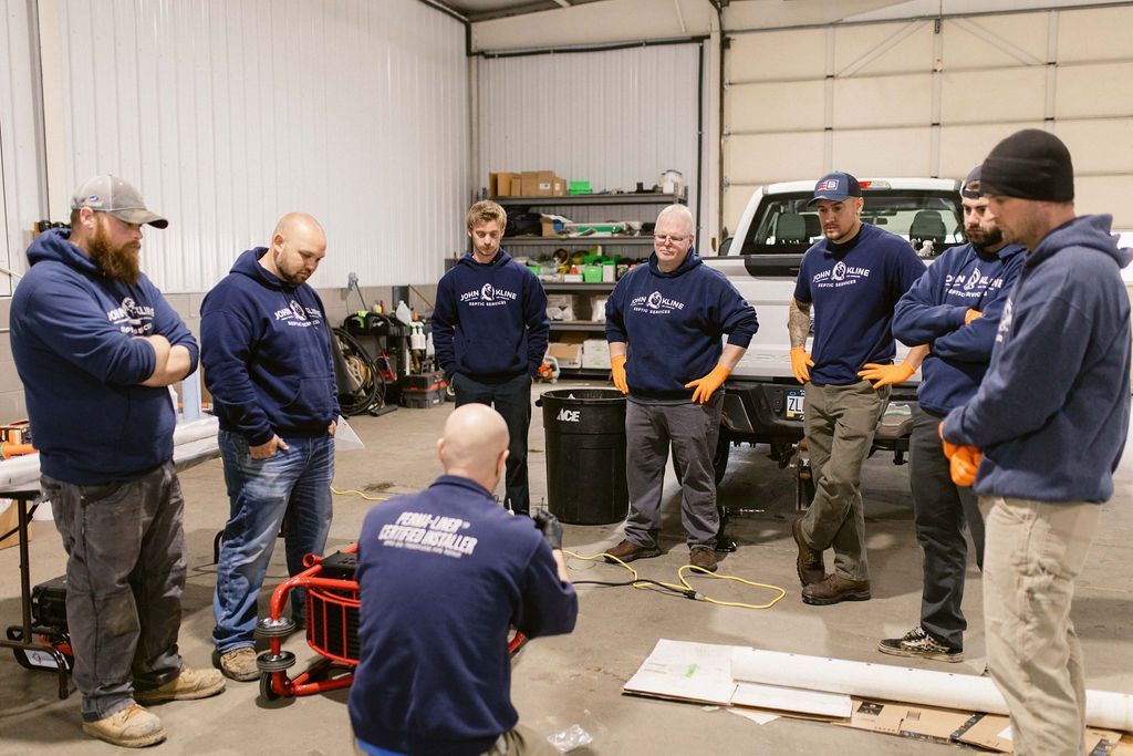 A group of men are standing in a circle in a garage.