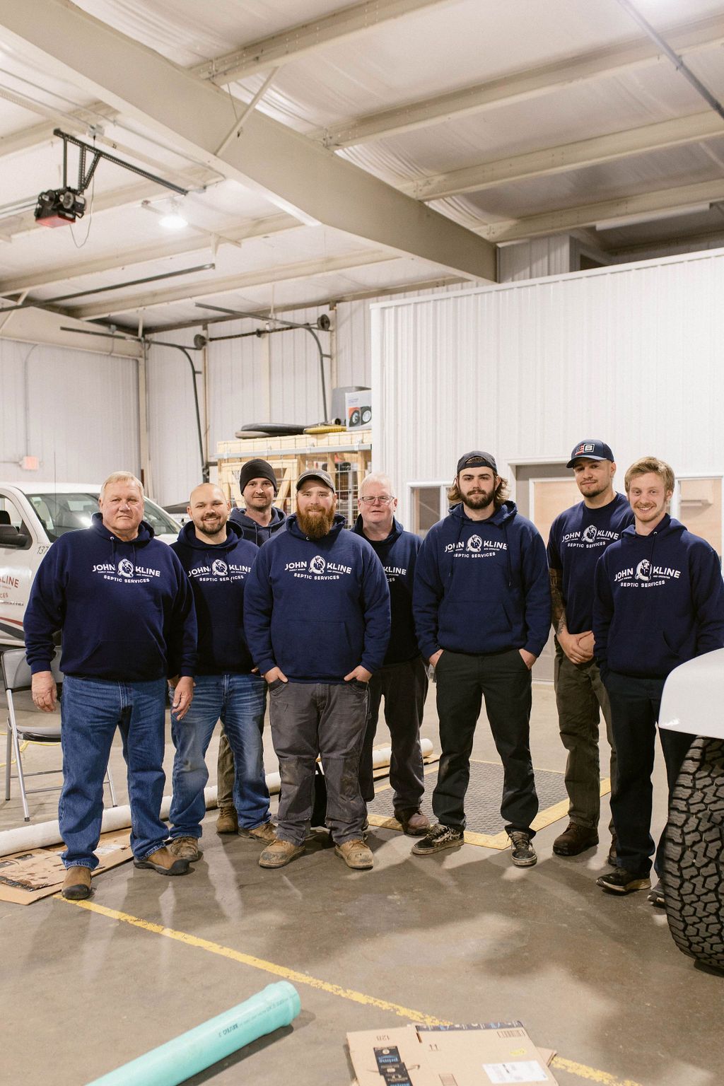 A group of men are posing for a picture in a garage.