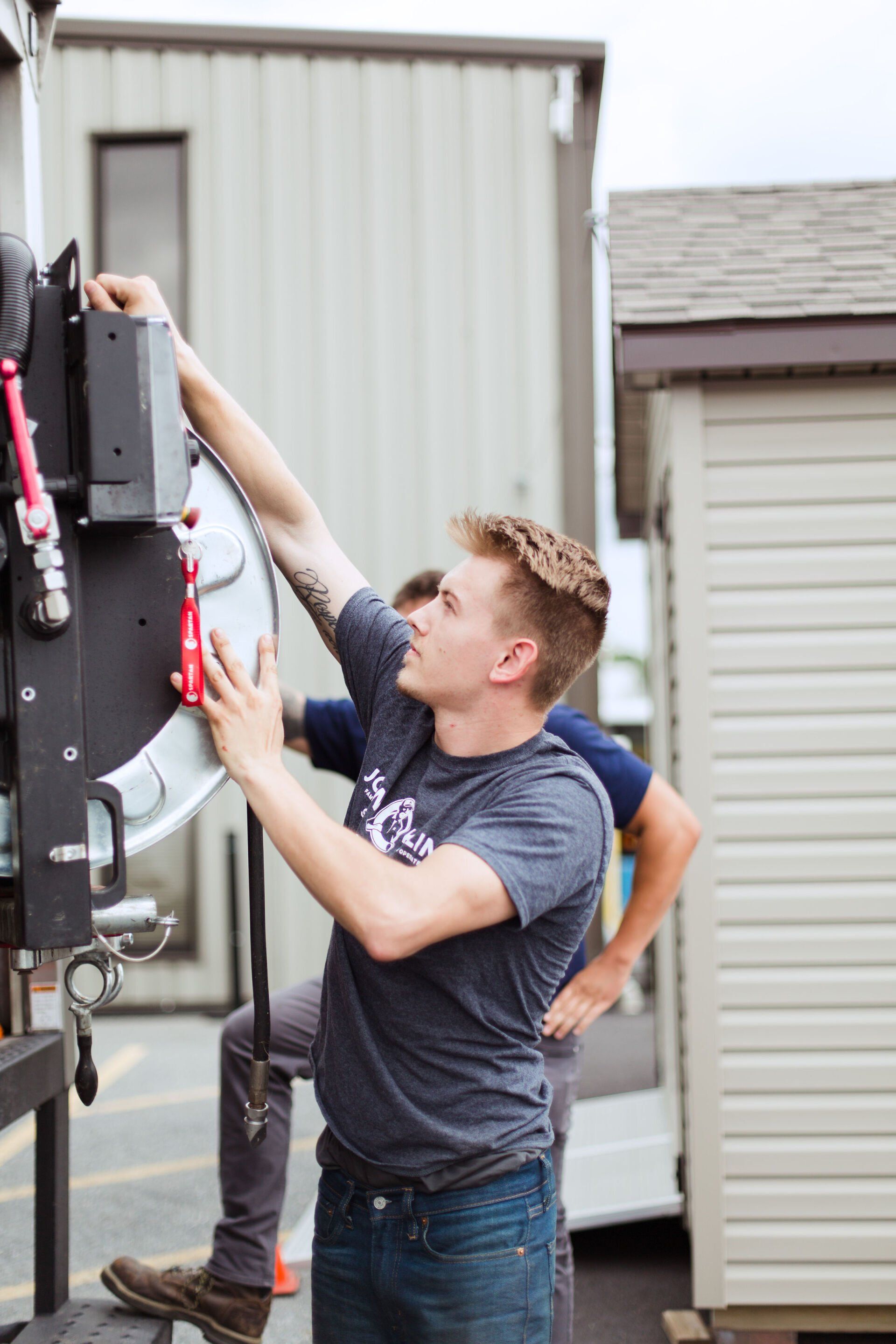 A man is working on a piece of equipment in front of a building.