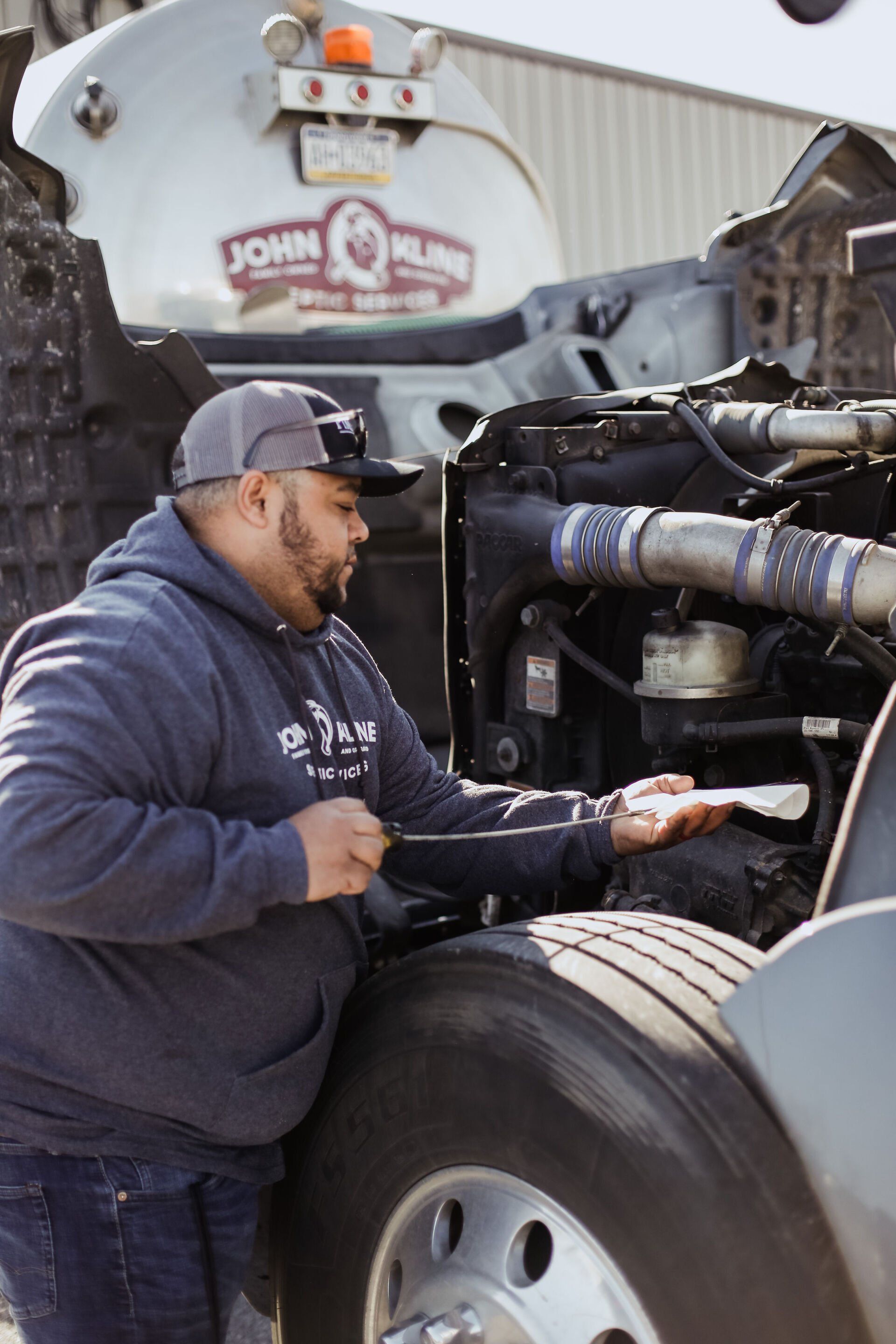 John Kline Septic Services Team Member Checking Oil in Truck