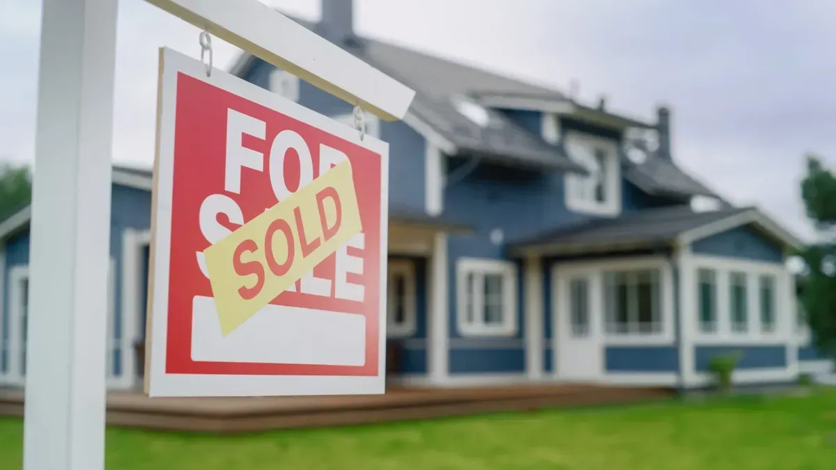 home for sale sign with blue house in background | John Kline Septic