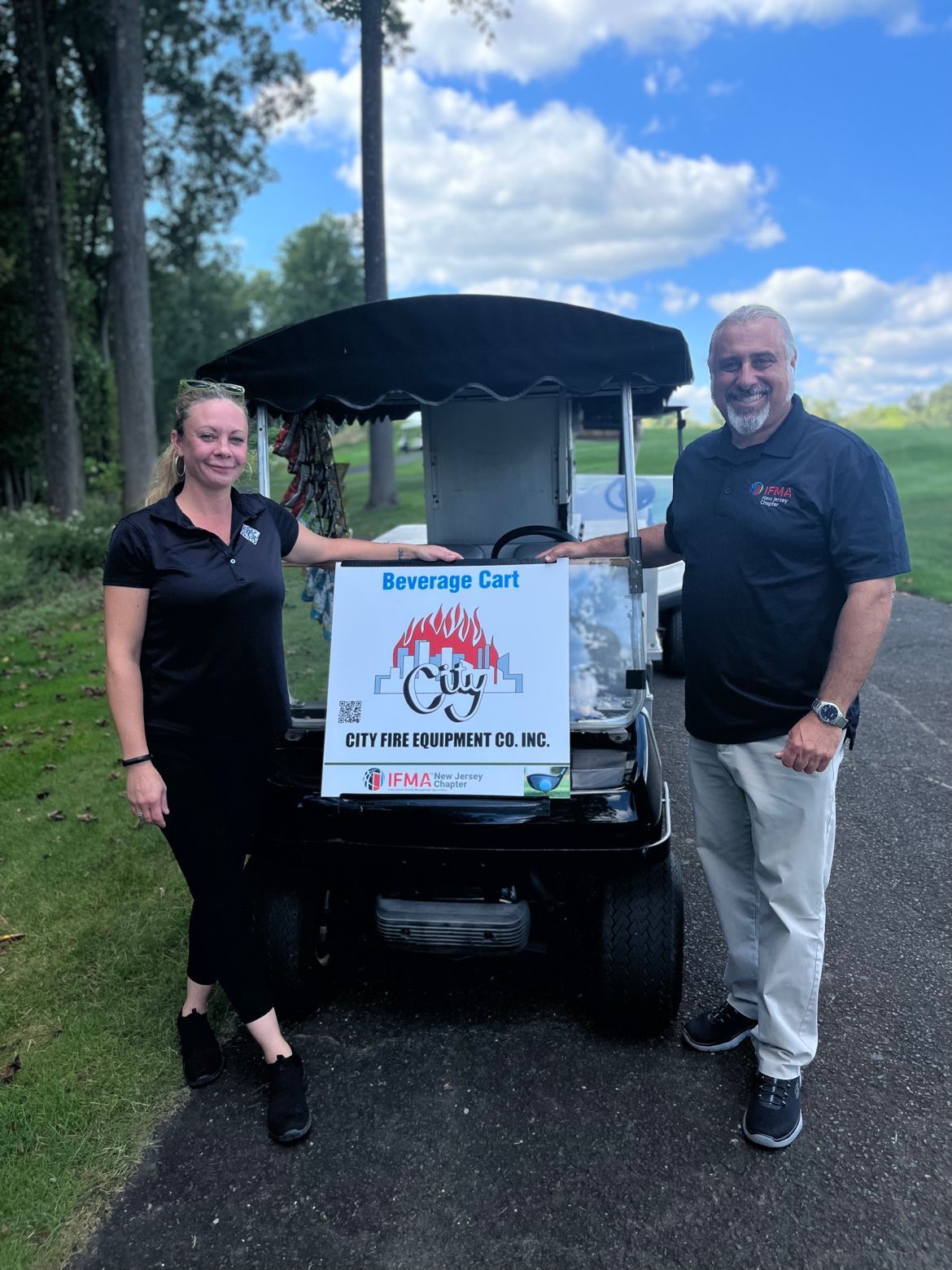 A man and a woman are standing next to a golf cart.