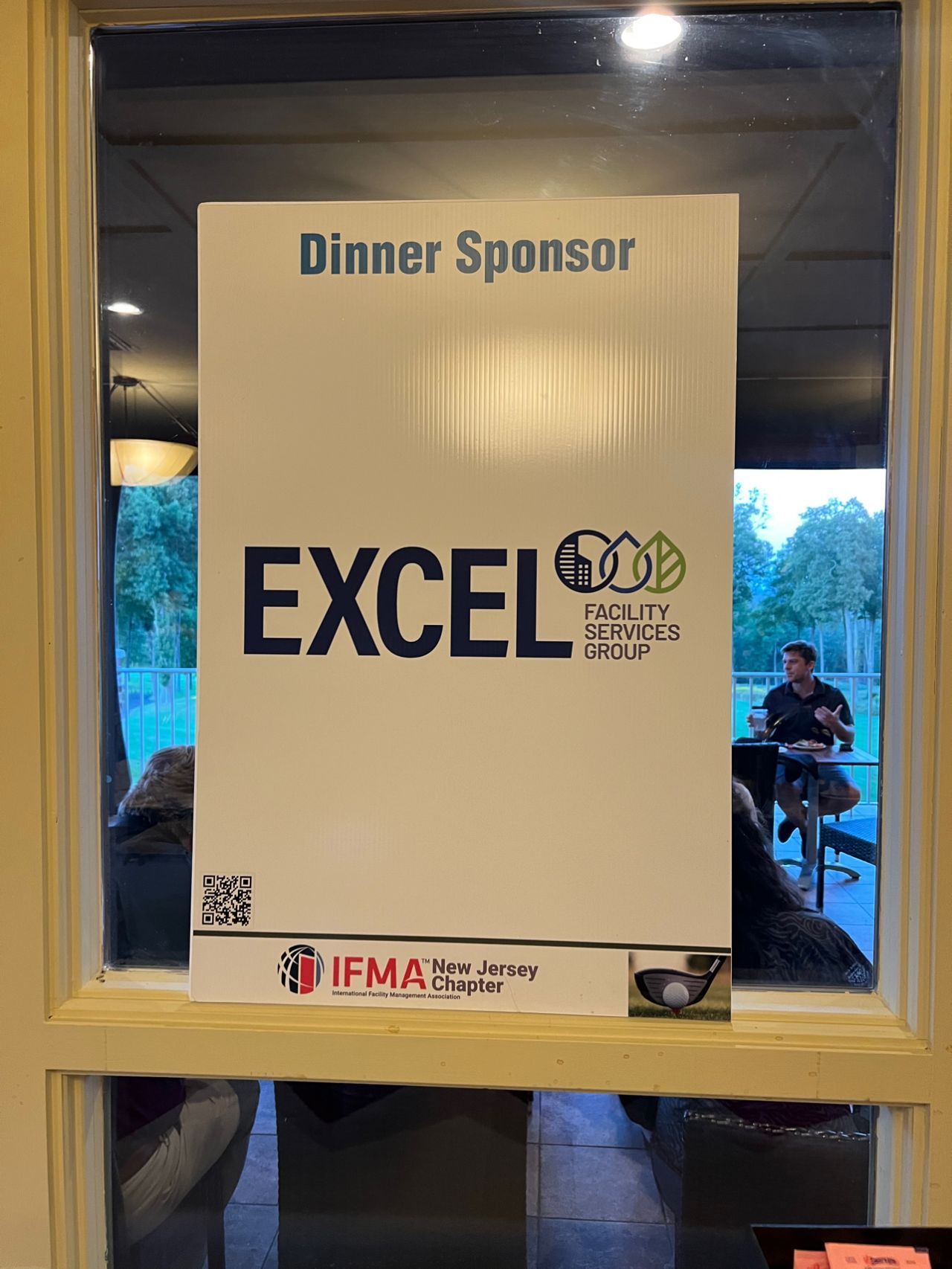 A sign in a window that says dinner sponsor excel