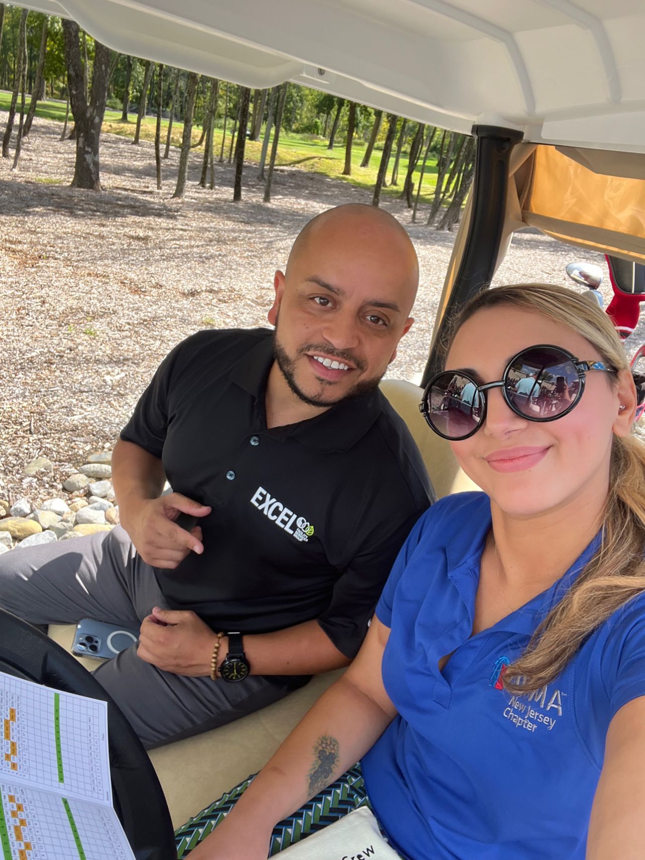 A man and a woman are sitting in a golf cart.