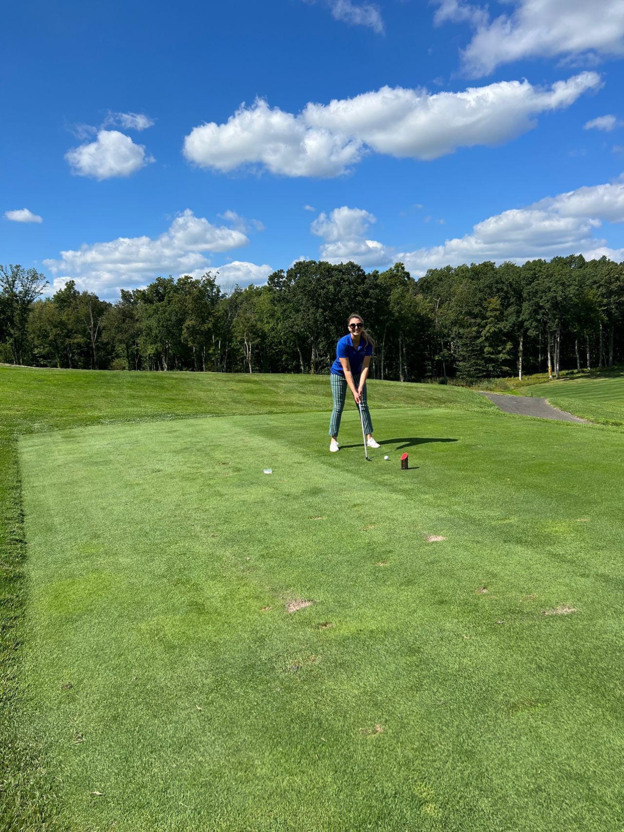 A man is swinging a golf club on a golf course.