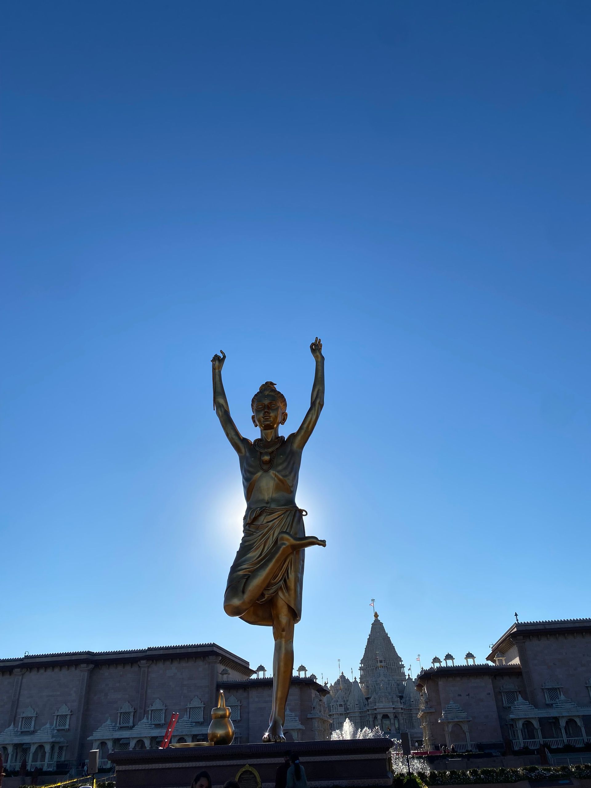A statue of a woman standing on one leg with her arms in the air