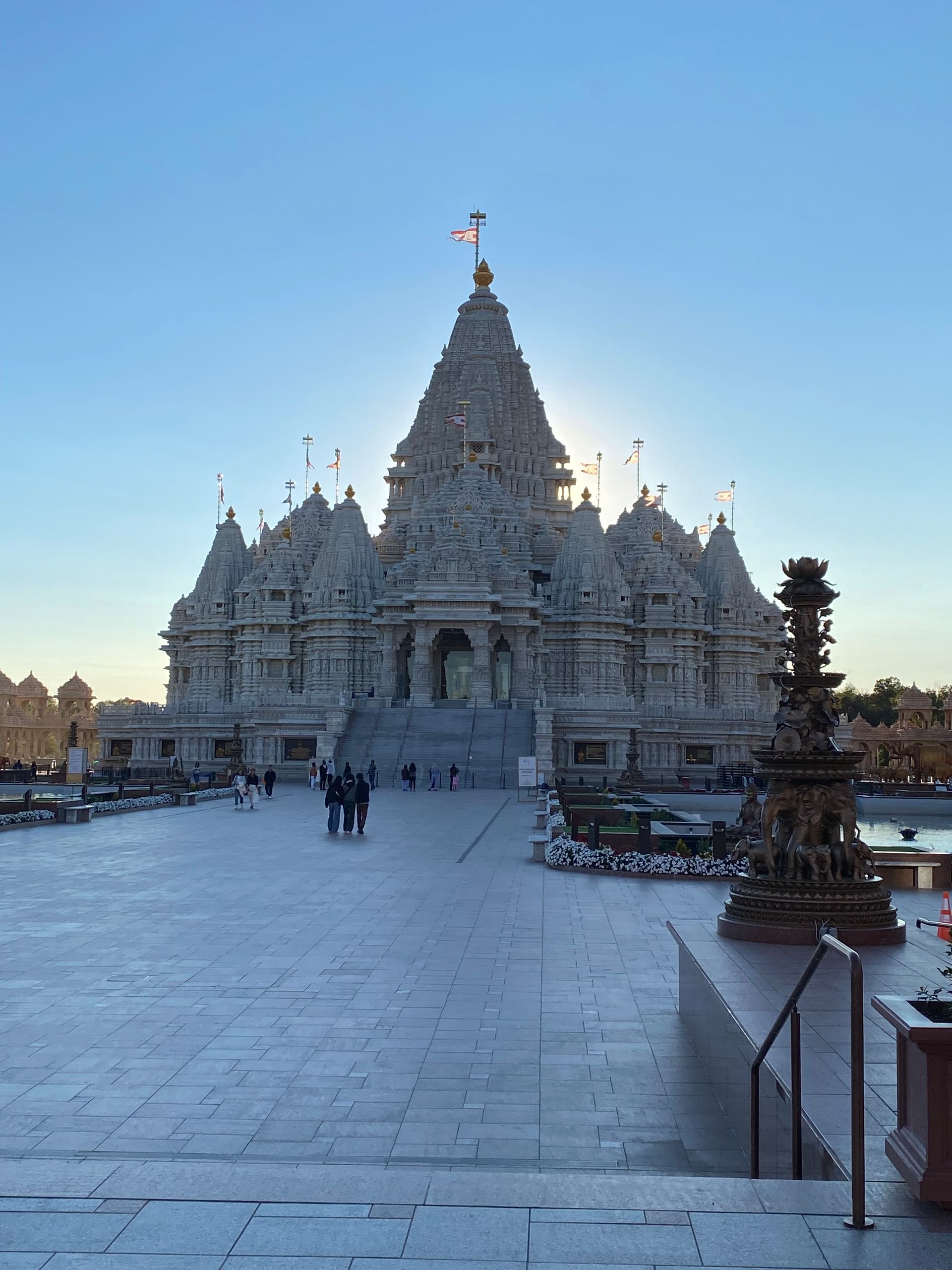 A large white temple with a flag on top of it