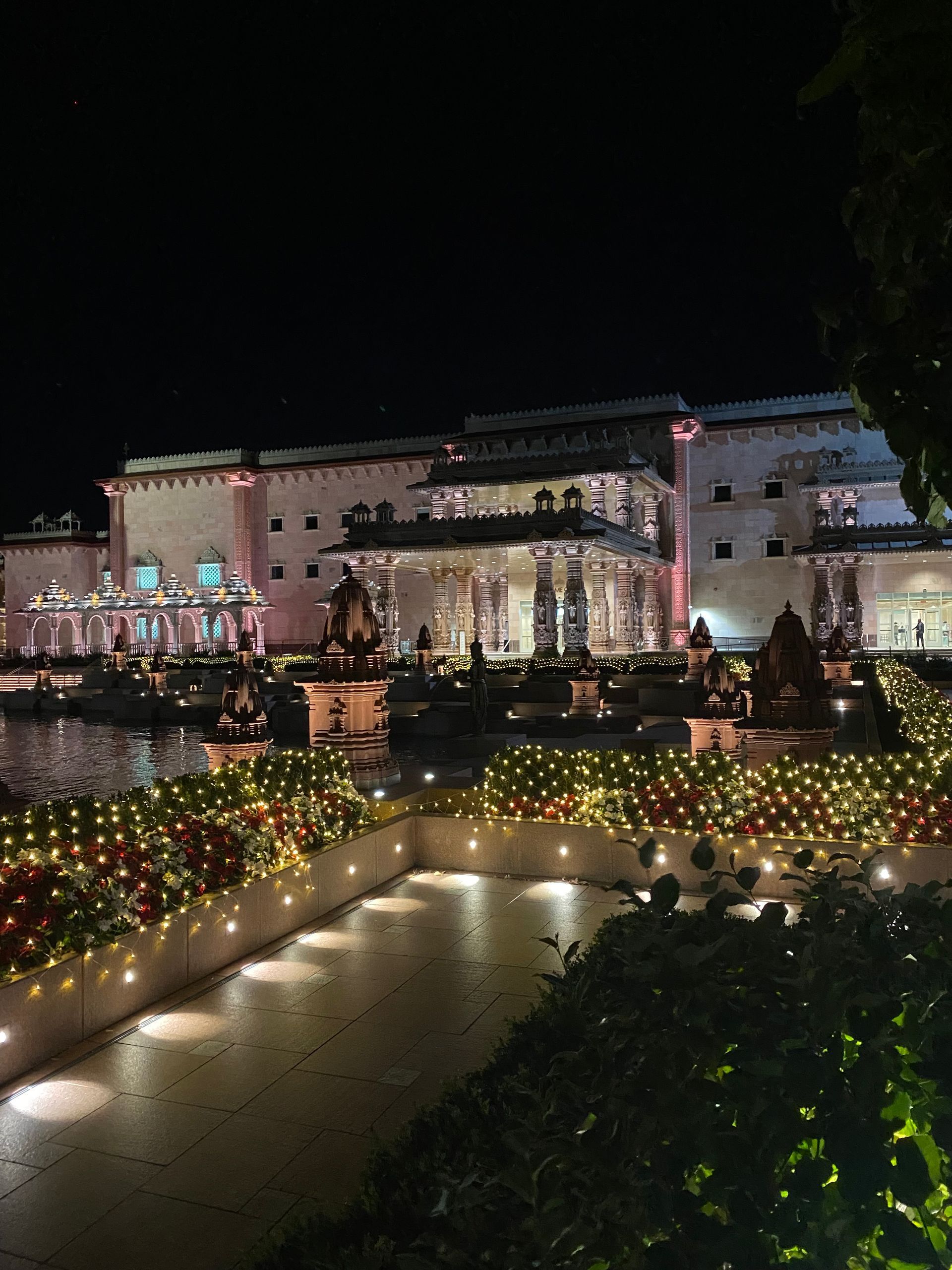 A large building with a lot of lights on it is lit up at night.
