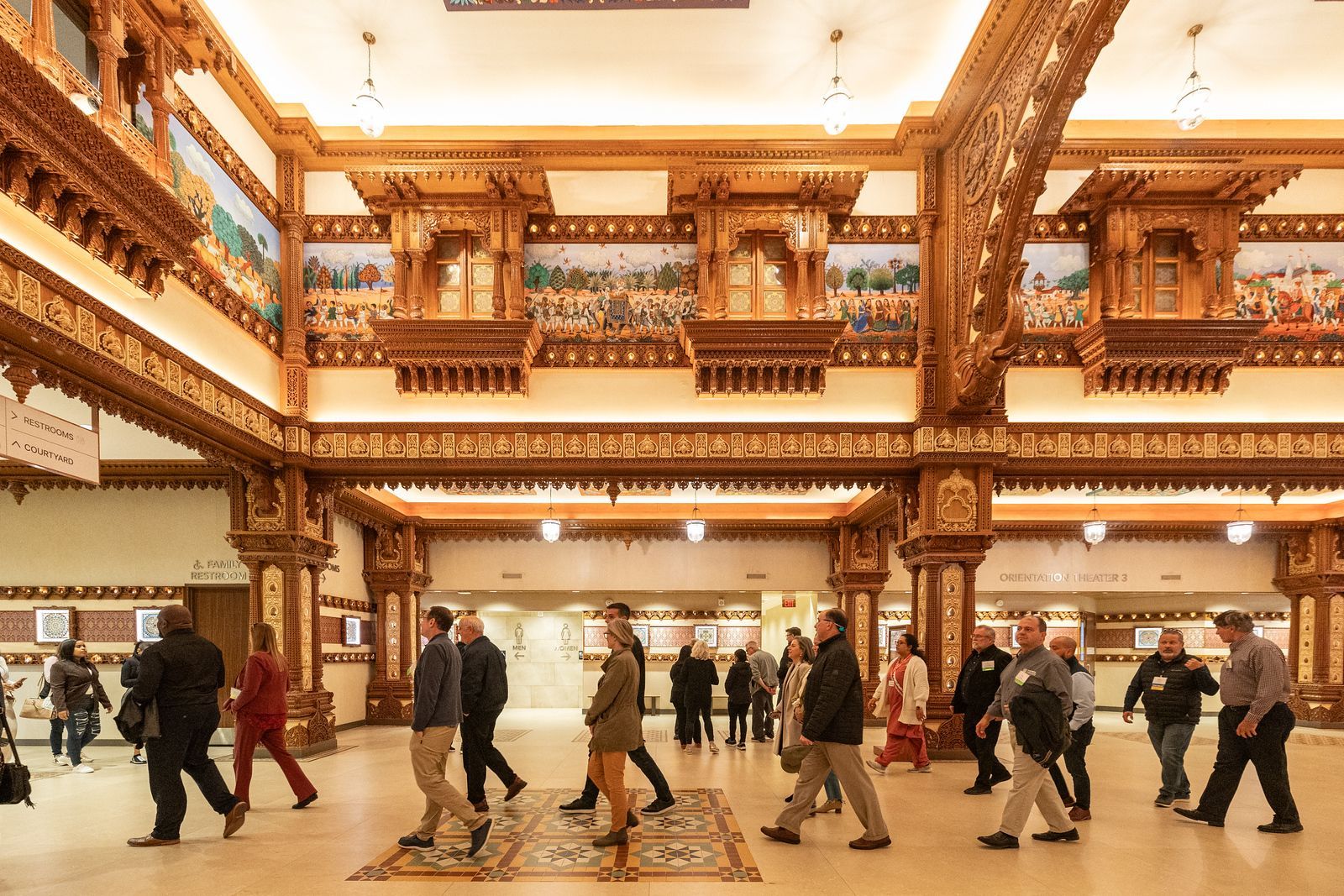 A group of people are walking through a large room in a building.