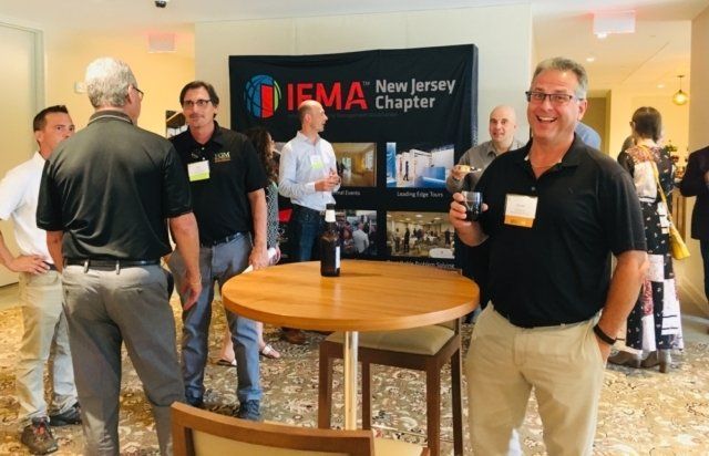 a group of people are standing around a table in front of a sign that says new jersey chapter