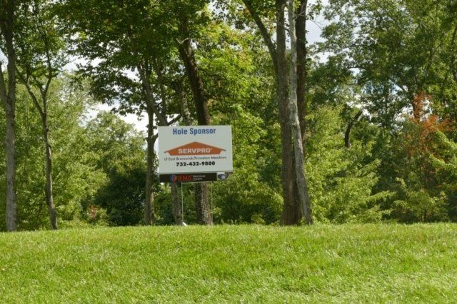 A sign in a grassy field says bone spencer